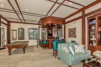 A living room with a pool table and a couch.